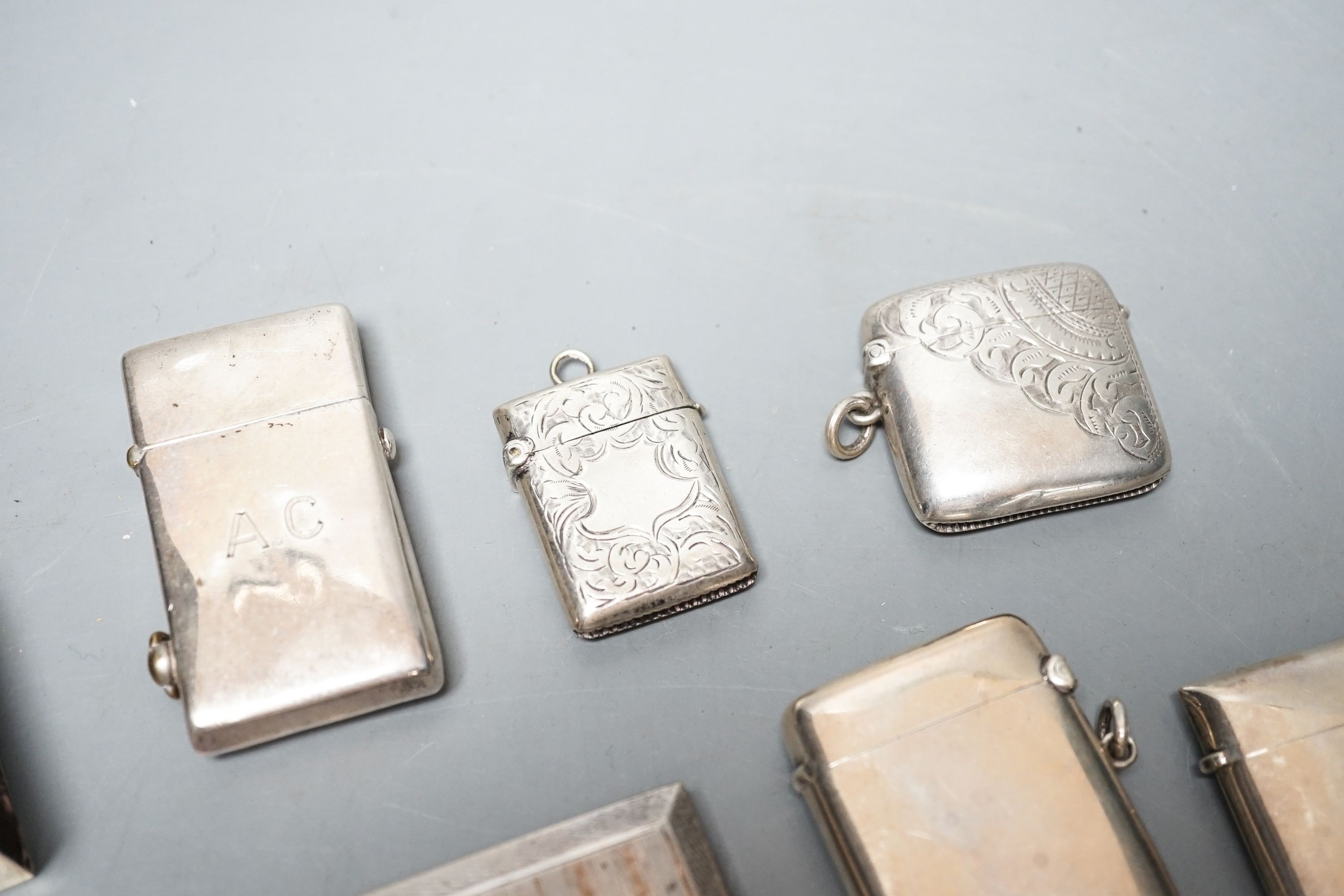 A group of assorted small silver to include four vesta cases, two cigarette cases (one plated), a card case, pill box, match sleeve and white metal mounted lighter.
